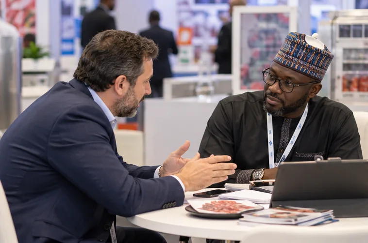 A supplier and buyer discuss a processing project at an expo